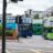 a couple of green double decker buses driving down a street