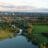 aerial view of green grass field near lake during daytime