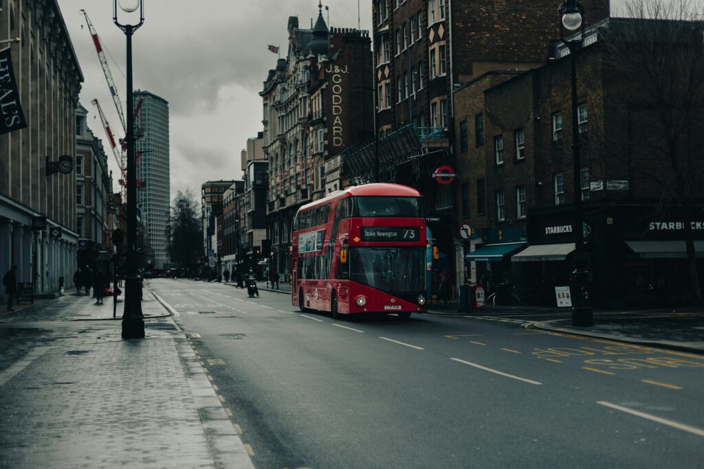 a red double decker bus driving down a street