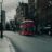 a red double decker bus driving down a street